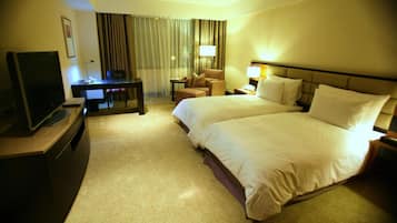 A hotel room with a bed, a desk, a television, and a chair.