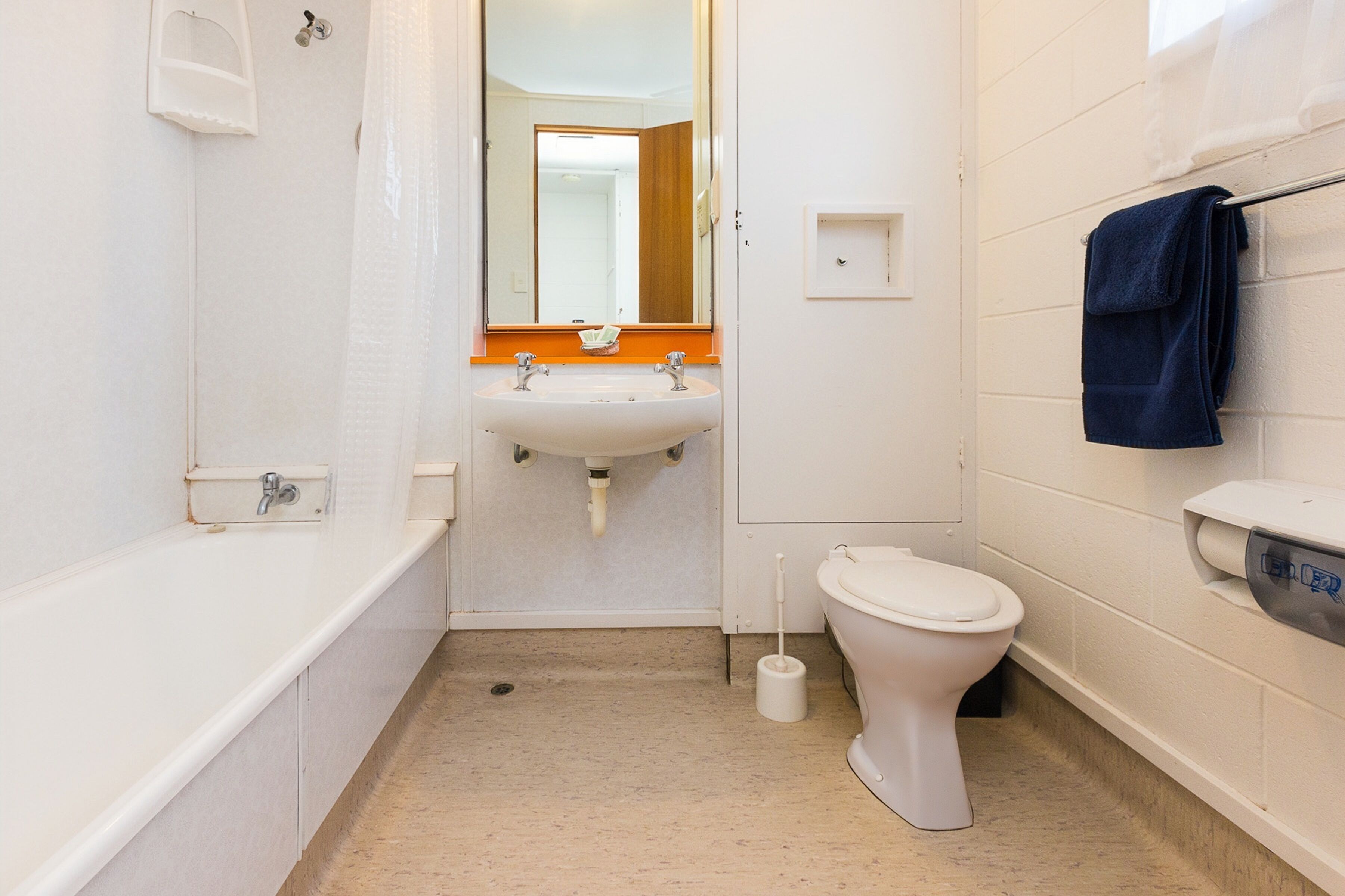 A bathroom with a bathtub, sink, toilet, and a towel rack.