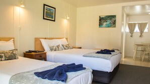 A hotel room with two beds, a desk, and a chair. - Alpha Motor Inn (Palmerston North)