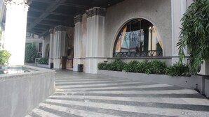 Un espace extérieur abrité, doté d’un sol en pierre, de colonnes et de fenêtres en arc de cercle.