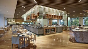 A spacious restaurant with multiple dining areas, a central counter with a variety of food items, and a modern ceiling design. - Rolling Hills Hotel (Hwaseong)