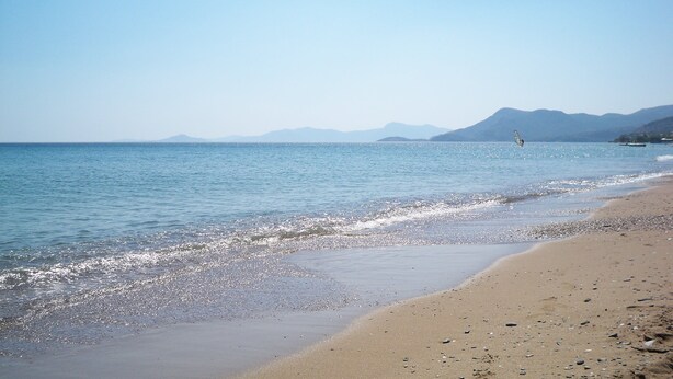 A beach with clear water, a sandy shore, and distant mountains. - Aphrodite Samos Superior Studios & Apartments (Samos)