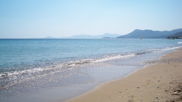 Perto da praia, espreguiçadeiras, guarda-sóis, toalhas de praia 