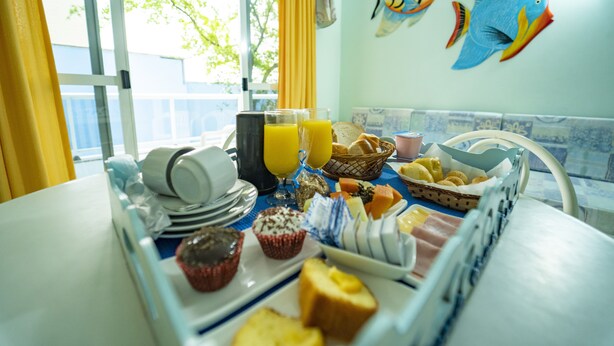 Un bufé de desayuno con diversas opciones de comida, platos y vasos de jugo de naranja sobre una mesa.