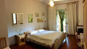 A bedroom with a bed, bedside tables, a mirror, and a ceiling fan. - Agriturismo ORIONE (Campo nell'Elba)