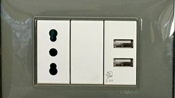 Eine an der Wand montierte Steckdose mit drei Schaltern und zwei USB-Anschlüssen, beschriftet mit "VIMAR".
