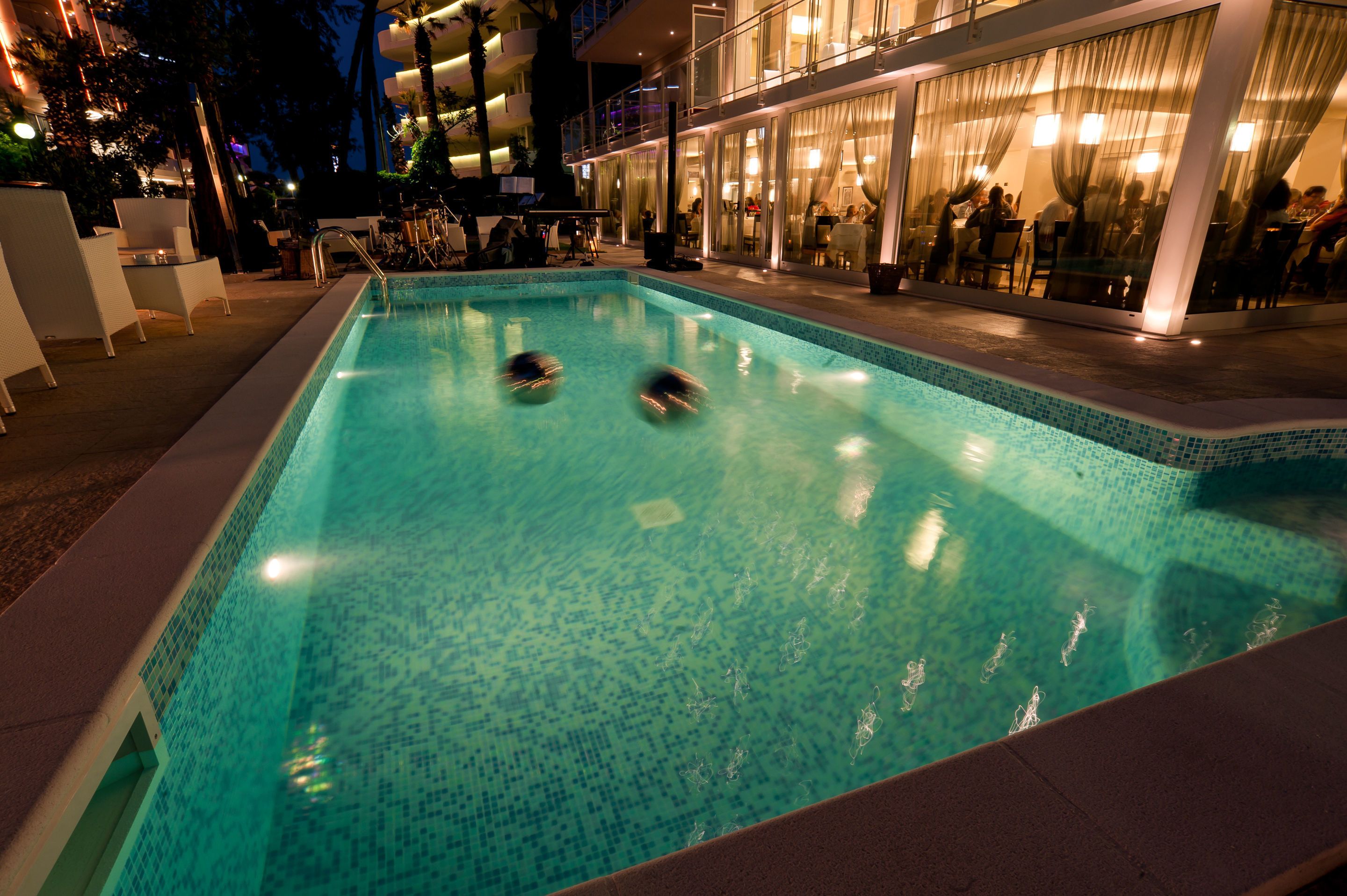 Una piscina al aire libre, sillones reclinables de piscina