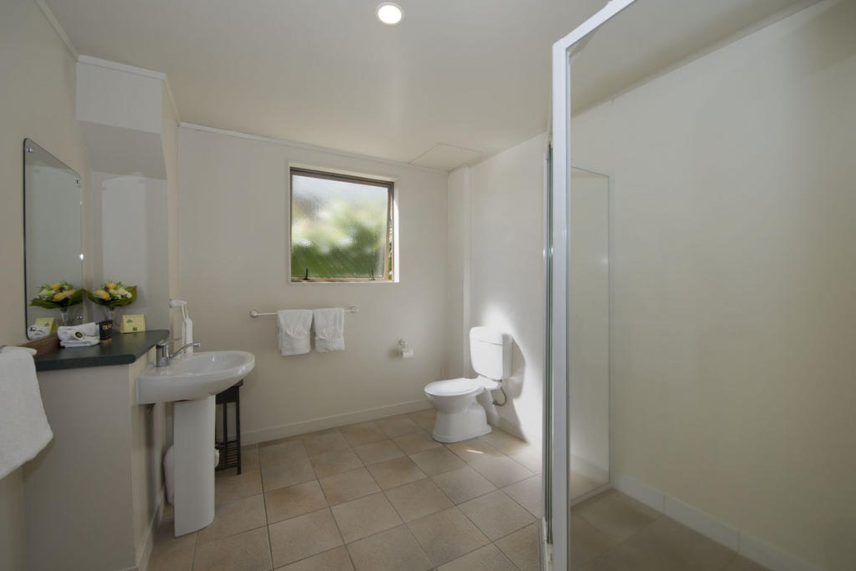 Un baño con lavamanos, inodoro y ventana.