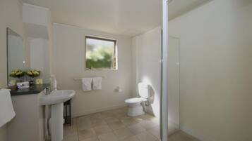 Un baño con lavamanos, inodoro y ventana.