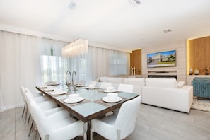 Enjoy formal dining and relaxation in this stylish living room with a large chandelier, flat-screen TV, and comfortable seating.