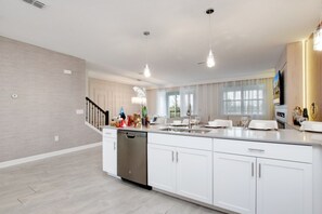 Enjoy cooking in the well-equipped kitchen with a central island, stainless steel appliances, and a dining area.