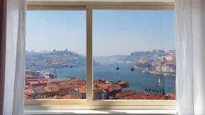 Vista dalla finestra su un paesaggio urbano con un fiume, edifici e funivie.