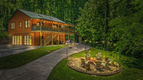 Une cabane en bois dotée d’un balcon, d’un foyer et d’un sentier pavé de pierres.
