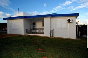 A single-story building with a flat roof, a covered entrance, and a small porch area.