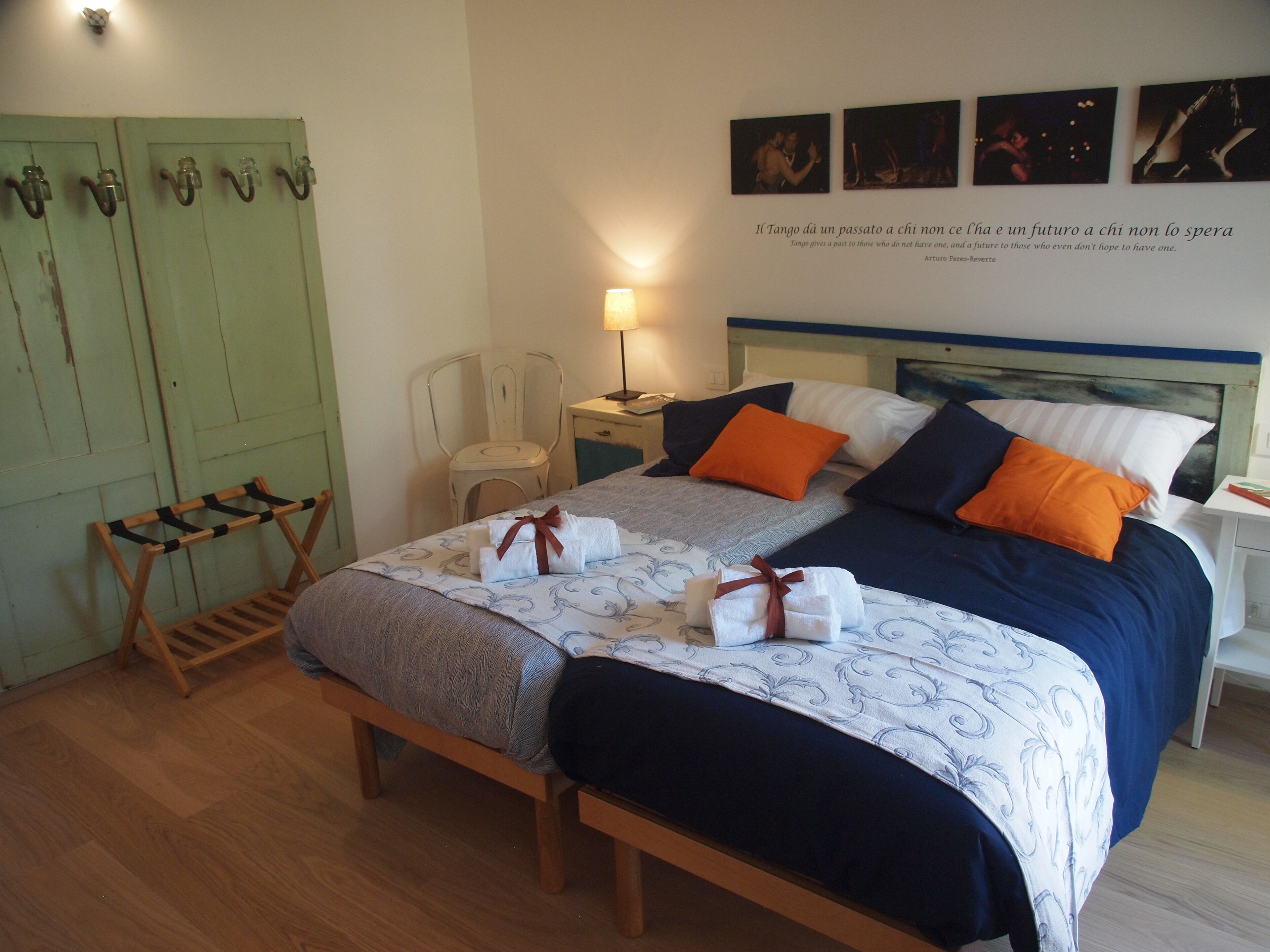 A neatly arranged bedroom with a bed, bedside tables, a chair, and a wooden bench.