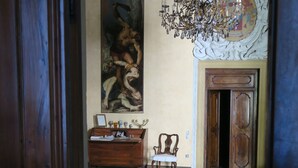A room with a wooden floor, a large painting on the wall, a wooden cabinet, and a chandelier. - Conti house, a cultural experience in the footsteps of Shakespeare (Padova)