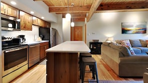 Enjoy cooking and relaxing in this well-appointed kitchen and living area with a central island, sofa, and coffee table.