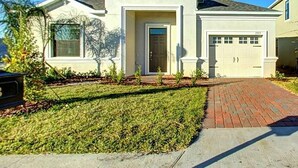 Une maison de plain-pied avec une porte d’entrée, un garage et une pelouse bien entretenue.