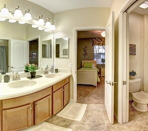 A bathroom with a double sink vanity, a large mirror, and a walk-in shower. - Lovely 4 Bd Providence at Victoria Woods-2353vd (Davenport)