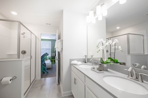 A modern bathroom with two sinks, a large mirror, and a shower area. - Lovely 8Bd Pool Spa Gm Hm Champions Gate-1579pd (Davenport)