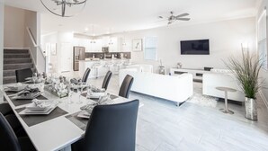 A modern kitchen with white cabinets, a central island, and bar stools. - Lovely 8Bd Pool Spa Gm Hm Champions Gate-1579pd (Davenport)