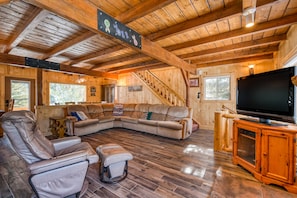 Relax in this inviting living room with a large L-shaped sofa, two armchairs, and a small ottoman.