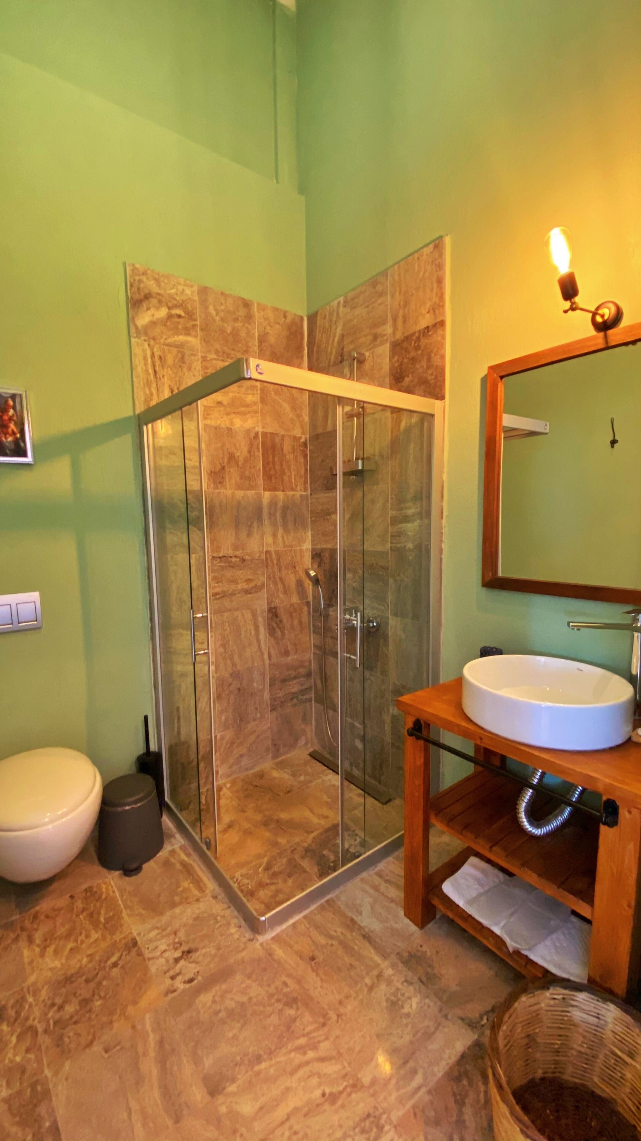 A bathroom with a glass-enclosed shower, a white sink, and a wooden vanity.