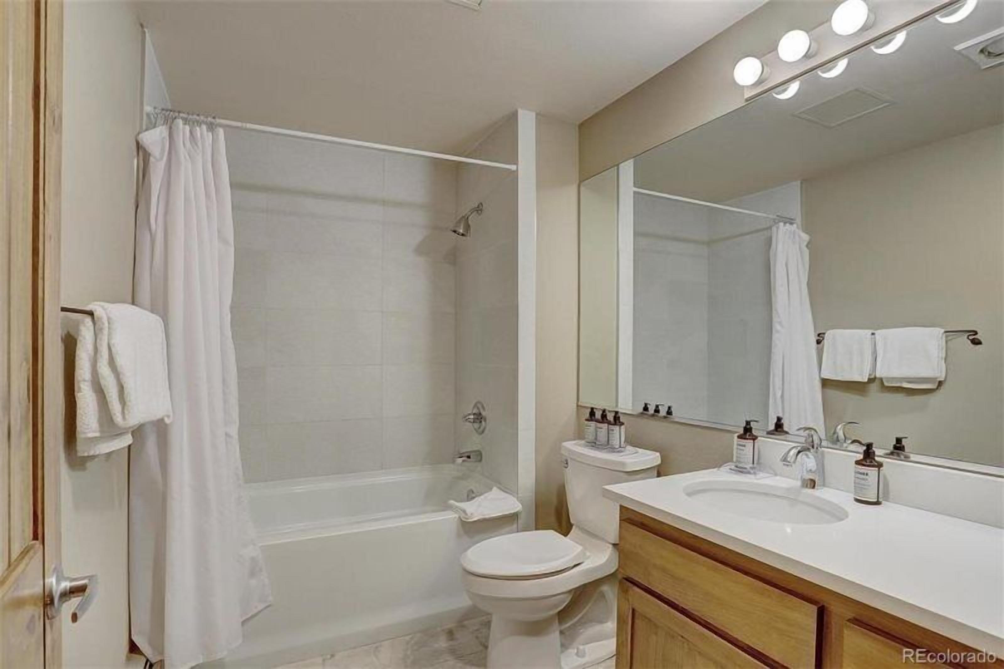 A modern bathroom with a bathtub, toilet, and sink.