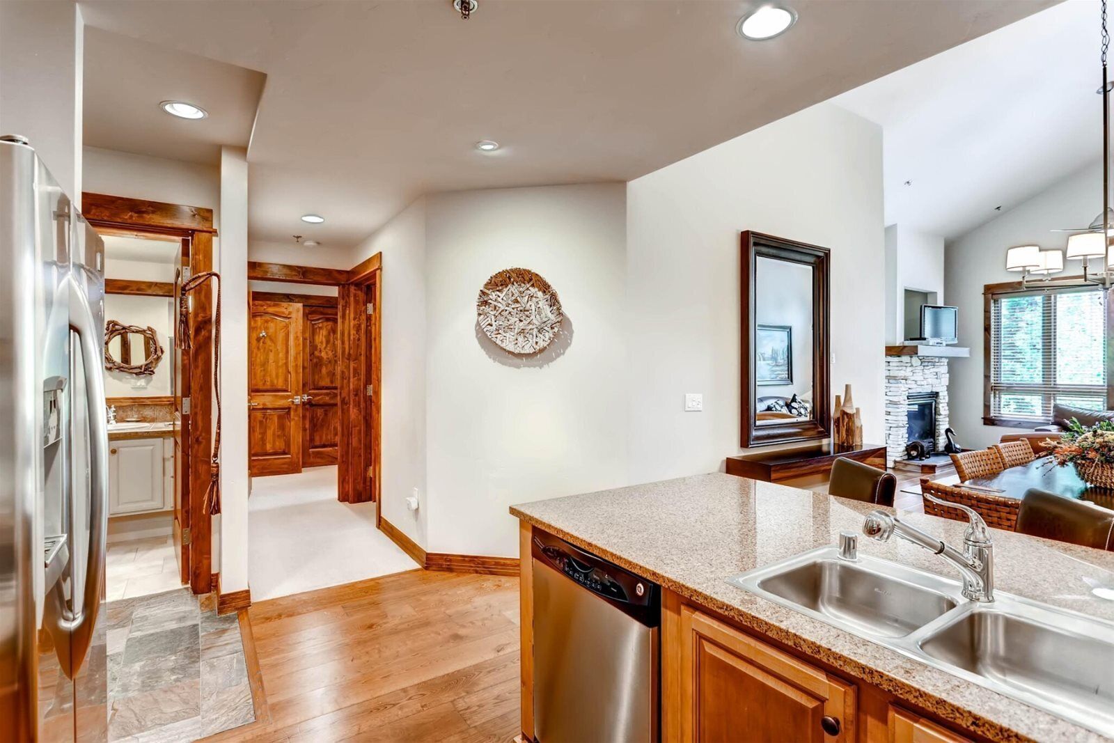 A modern kitchen with a dishwasher, granite countertops, and wooden cabinets.