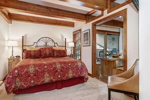 A bedroom with a large bed, wooden ceiling beams, a wooden chair, and a balcony with a view. - 1 Bedroom Antlers Vacation Rental With Incredible Slopeside Views and Just a Short Walk to Gondola and Lionshead Village (Vail)