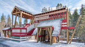 Une cabane en bois avec un escalier raide et une façade rouge et blanche.