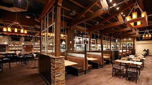 A restaurant with wooden beams, stone pillars, and multiple seating areas including booths and tables. - Ski in, Ski out 2 Bedroom Mountain Condo at the Base of Peak 7 with Quick Access to Historic Downtown Breckenridge (Breckenridge)