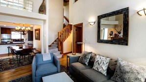 A spacious living area with a staircase, a dining area, and a kitchen.