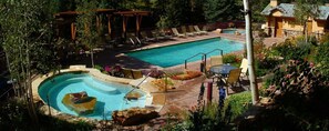 Ein Swimmingpool mit Whirlpool, Liegestühlen und einer Pergola.
