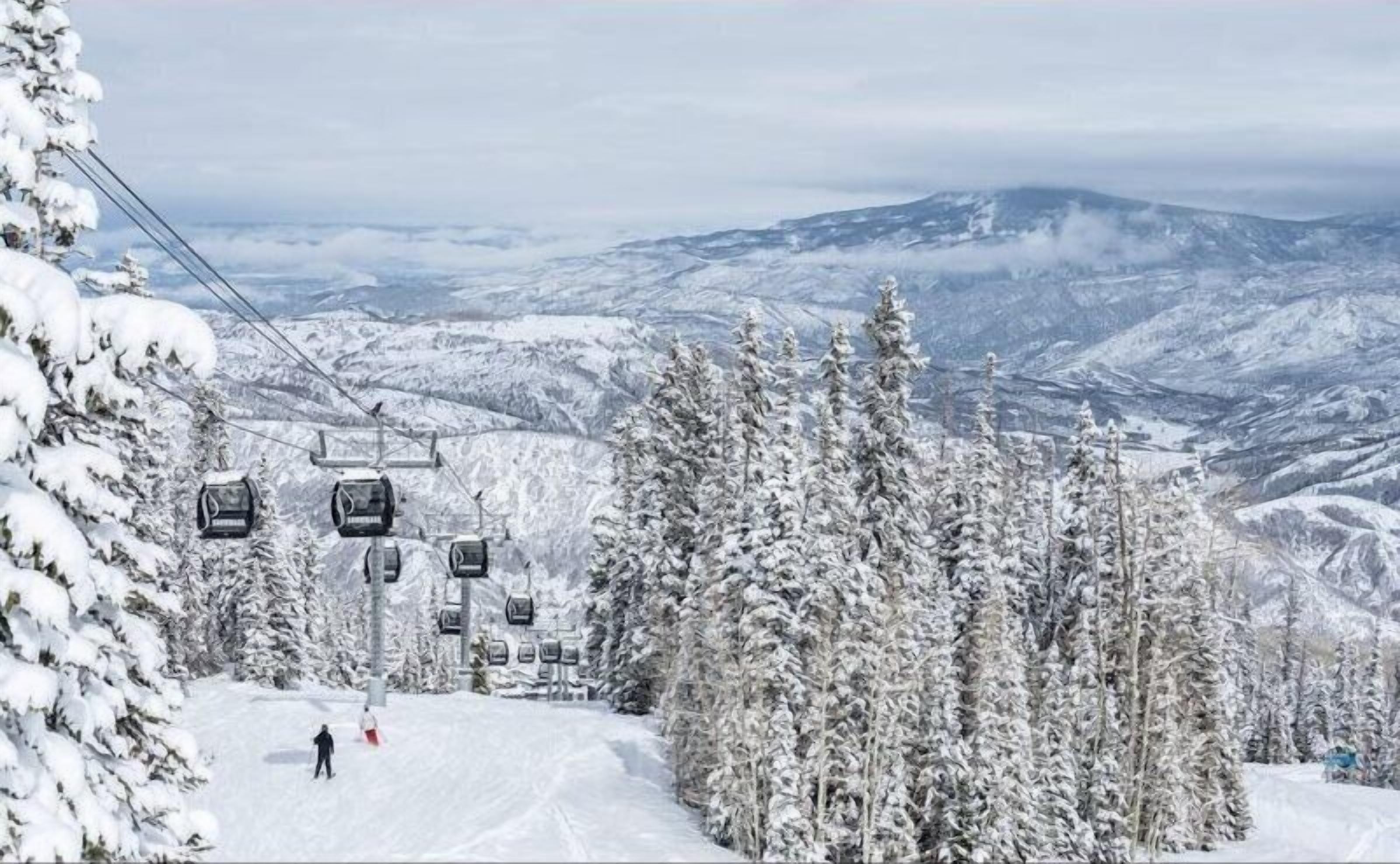 A ski lift with cabins and a skier on a snowy slope.