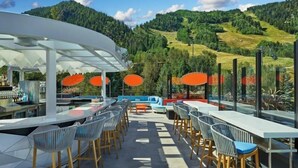 An outdoor bar area with seating and a view of a mountainous landscape. - Downtown Aspen Luxury 3 Bedroom Residence (Aspen)
