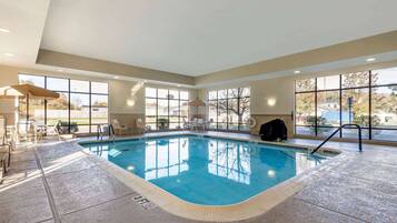 Relax by the pool with lounge chairs and a table nearby.