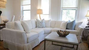 A modern living room with a white sectional sofa, a coffee table, and a lamp. - 600ft from Beach Ocean view Heated Pool 4BR 4ba sleep11. 44 Summer Place 30A (Santa Rosa Beach)