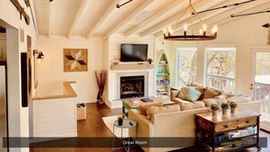 A spacious living room with a fireplace, a television, and a comfortable seating area.
