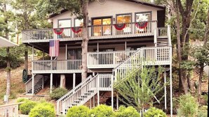 A two-story building with a balcony, a flag, and a dock in the foreground.