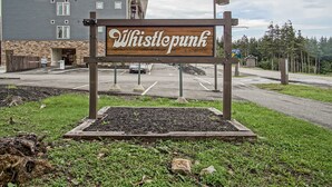 A Whistlepunk sign in front of a building with a balcony and a parking lot. - Whistlepunk 36: 1 Br Plus Bonus Sleeping Loft Slope Side (Snowshoe)