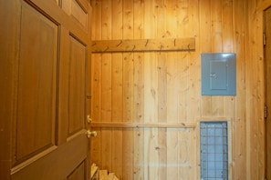 A wooden-paneled room with a door, a metal vent, and a small electrical box on the wall. - Whistlepunk 40 Bavaria`s Finest-1 bedroom with loft, Slope Side (Snowshoe)
