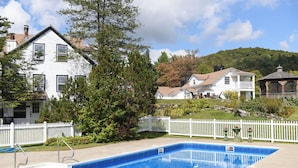 A swimming pool with a white picket fence, surrounded by houses and a gazebo. - Deluxe King - 2nd floor in Historic Inn (West Dover)