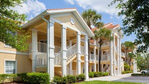 A multi-story hotel with a light-colored facade, balconies, and palm trees. - Vacation in Paradise. New Kitchen, New bedroom furniture. (Naples)
