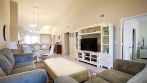 A living room with a TV, sofas, and a dining area with a kitchen in the background. - Vacation in Paradise. New Kitchen, New bedroom furniture. (Naples)