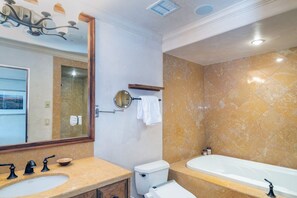 Een badkamer met een wastafel, toilet en bad.