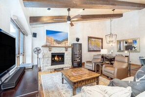 A spacious living room with a fireplace, a television, and comfortable seating.