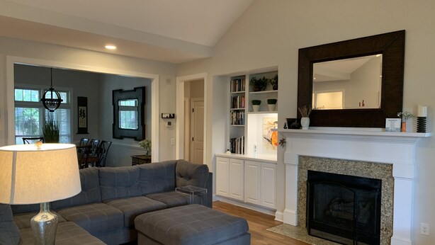 A living room with a sectional sofa, ottoman, and a fireplace. - LUXURY HOME INCLUDES GOLF CART walking distance to historic village center (Pinehurst)