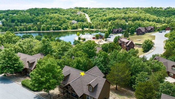 Un barrio residencial con casas, un lago y una carretera.