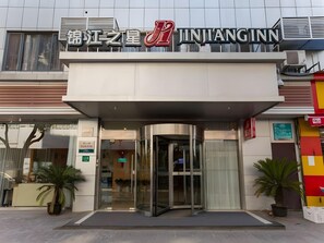 A hotel entrance with a modern design, featuring a glass door and a covered entrance area. - Jinjiang Inn (Shanghai Changzhong Road Subway Station) (Shanghai)